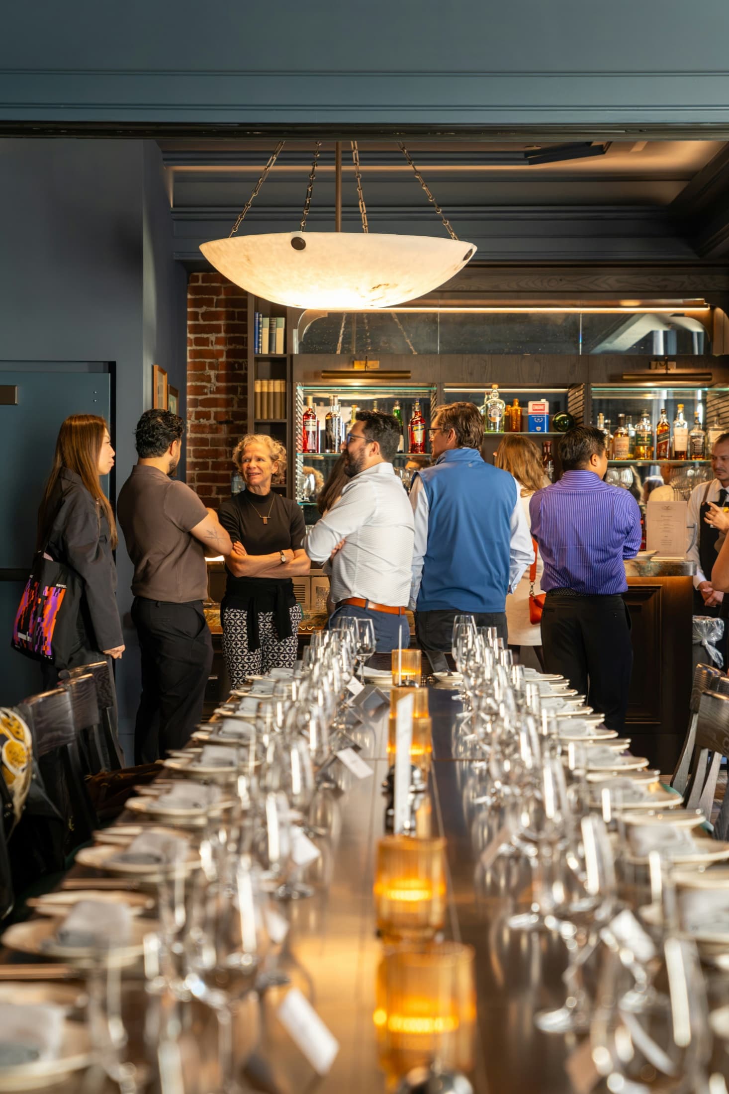 Members gathering before a private dinner at a long table