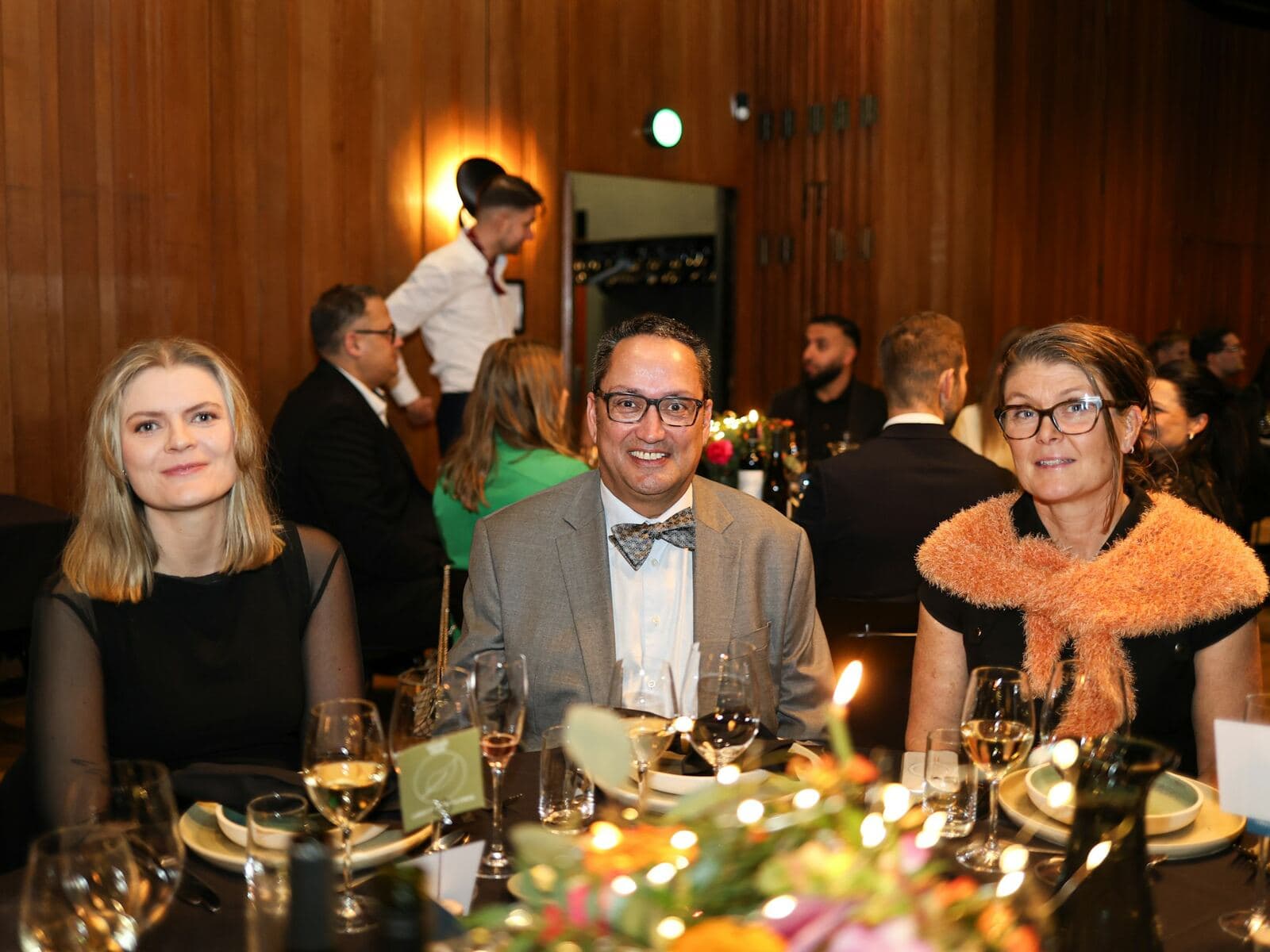 Three members seated together at a formal dinner table